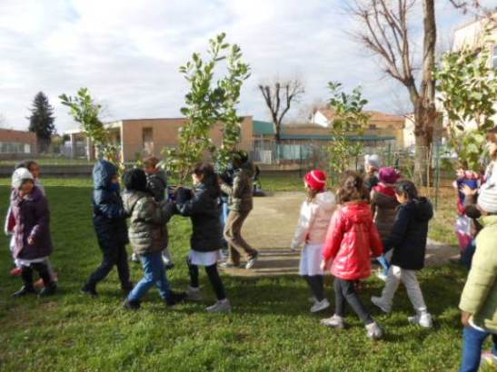 Gli alunni portano i vasi nel luogo di piantumazione.