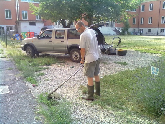 Un volontario riassesta il terreno nel giardino Un volontario riassesta il terreno nel giardino