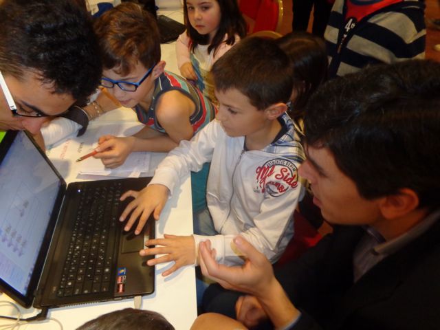 I giovani sperimentatori mortaresi discutono al computer con l'ingegner Daniel DelRio (a destra) e con Giorgio Marcianò (a sinistra, organizzatore della manifestazione), che ci fa anche da interprete. I giovani sperimentatori mortaresi discutono al computer con l'ingegner Daniel DelRio (a destra) e con Giorgio Marcianò (a sinistra, organizzatore della manifestazione), che ci fa anche da interprete.