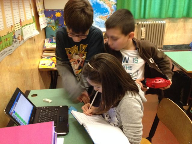 Alunni al lavoro con carta e computer