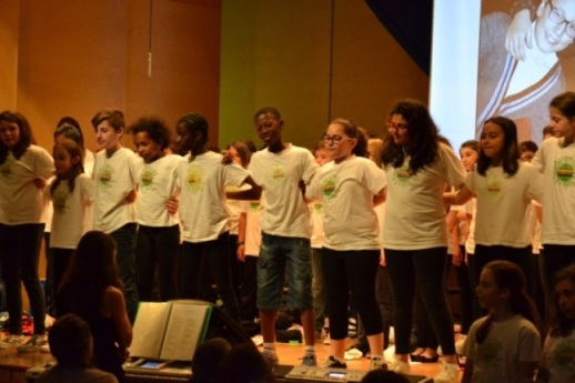 Gli alunni cantano abbracciandosi.