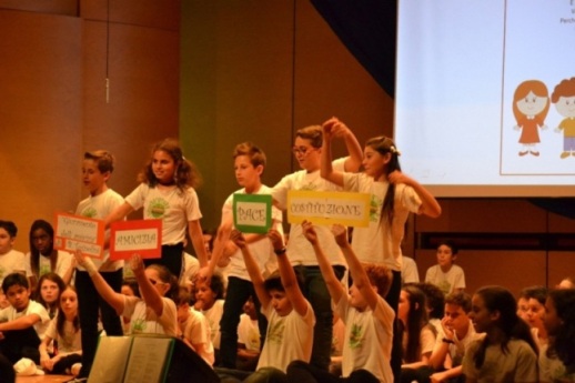 Gli alunni mostrano cartoncini colorati con le scritte Amicizia, Costituzione e Pace.