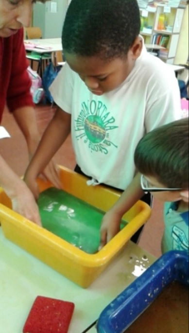 Omar raccoglie con il setaccio poltiglia verde.